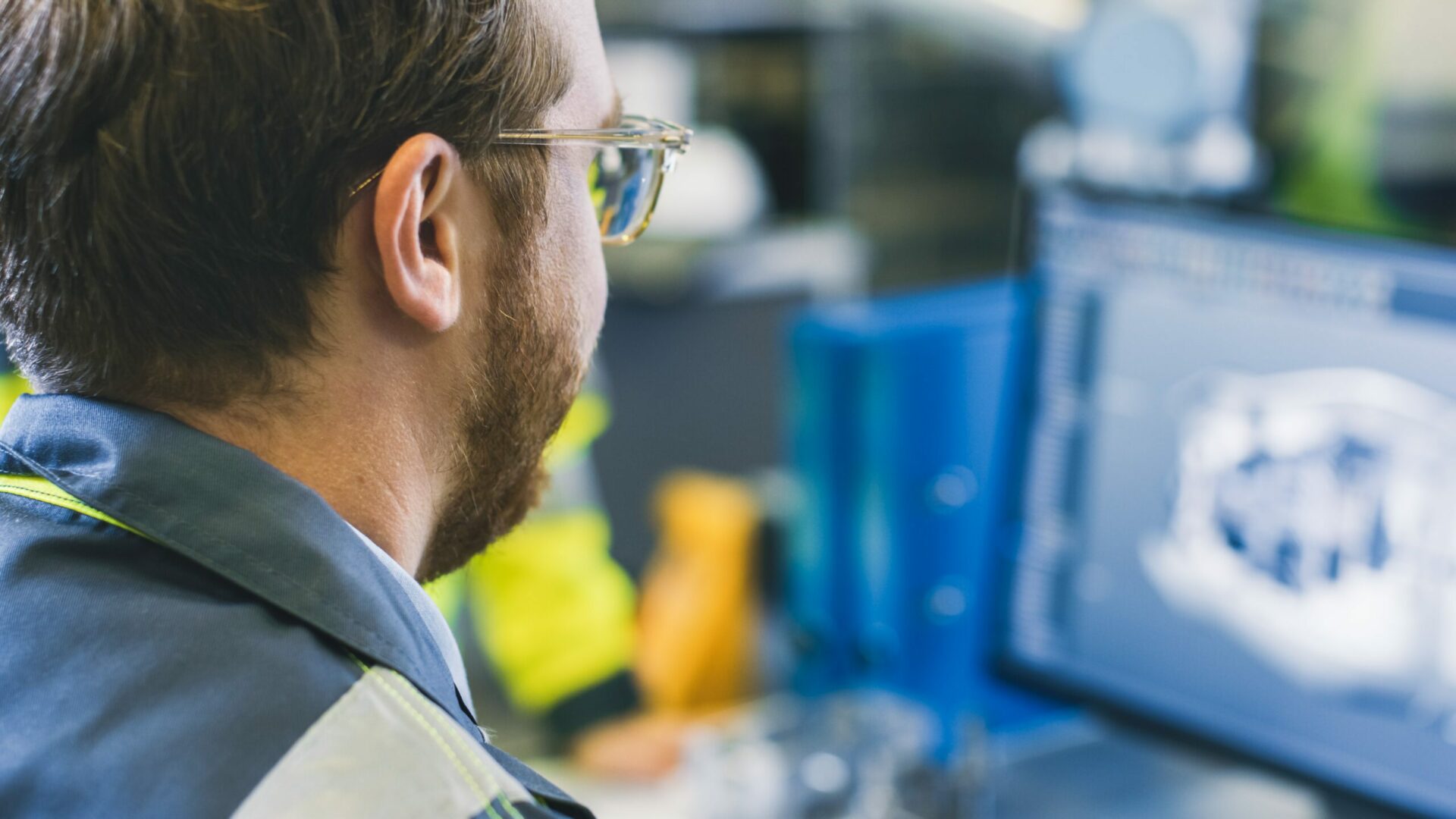 Close-up Back View of the Mechanical Engineer Designing 3D Engine Model on Personal Computer. Professional Working At the Factory.